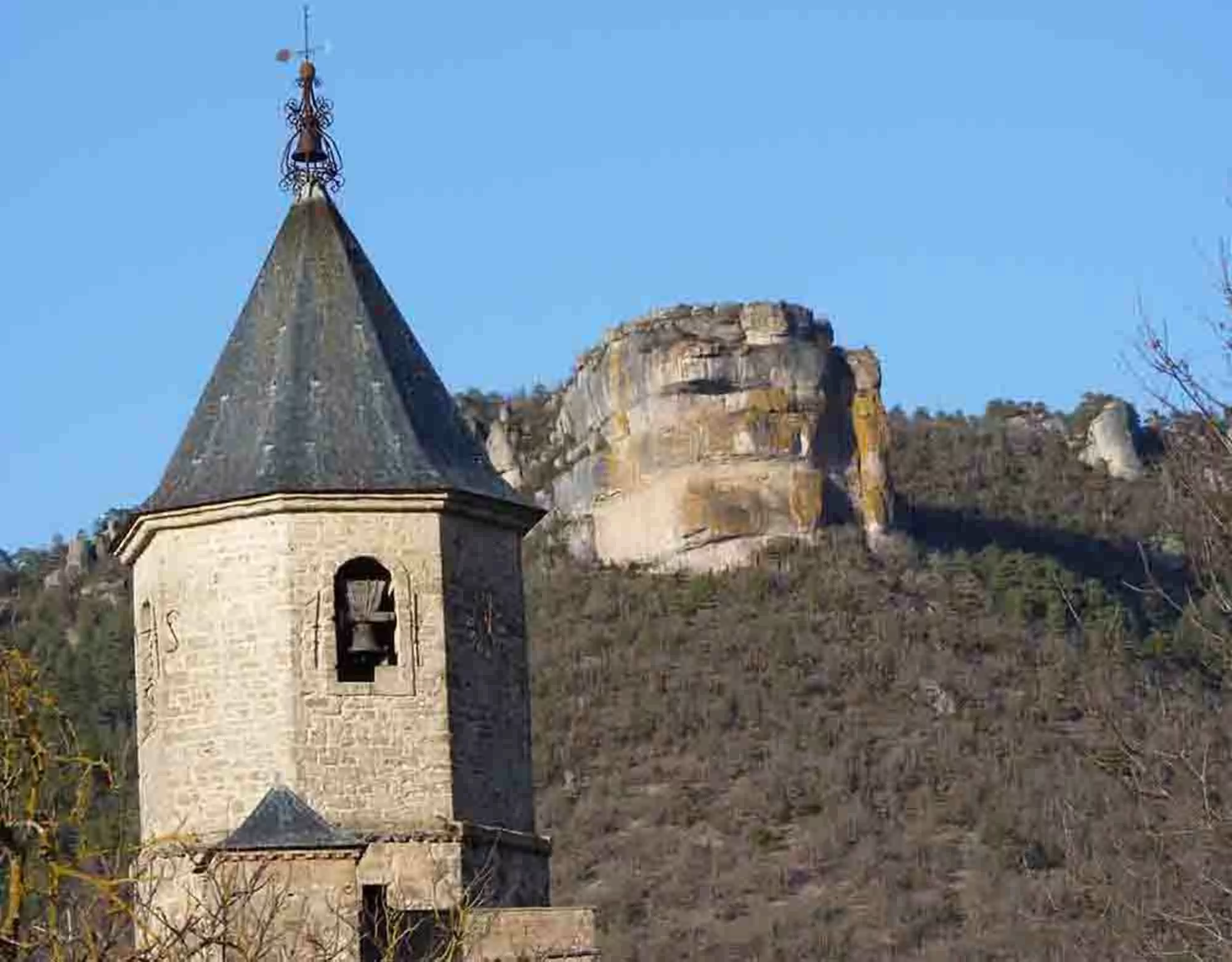 Le Roc Nantais à Nant en Aveyron en arrière plan de l'église Saint-Pierre du XIIe siècle.